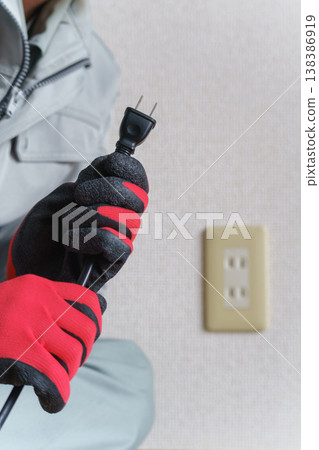 一名工人手持插頭和電源插座。 138386919