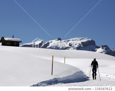 trekker near wooden hut covered by snow in armentarola pralongi? dolomites mountains trekker near wooden hut covered by snow in armentarola pralongi? dolomites mountains 138387612