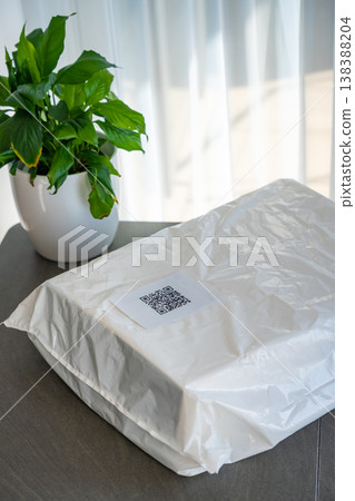 Packed parcel with QR code label ready for shipping placed on table at home. Delivery preparation completed with digital tracking and logistics concept. Packed parcel with QR code label ready for shipping placed on table at home. Delivery preparation completed with digital tracking and logistics concept. 138388204
