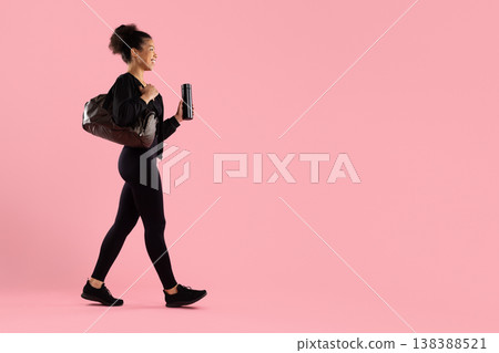 Young athletic black woman walking with gym bag and water bottle Young athletic black woman walking with gym bag and water bottle 138388521