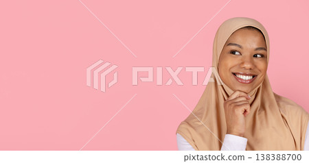 Young black Muslim woman in hijab smiling and looking aside thoughtfully Young black Muslim woman in hijab smiling and looking aside thoughtfully 138388700