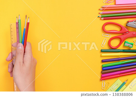 Hand holding pencils and ruler with school supplies Hand holding pencils and ruler with school supplies 138388806