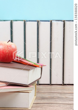 Stack of books with apple and pencils 138388820