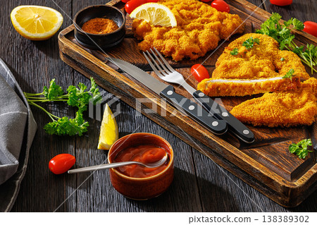 Crispy meat schnitzel served on wooden cutting board 138389302