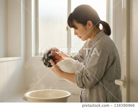 一位日本母親正在溫柔地幫寶寶洗澡，為她泡泡泡浴。 138390966