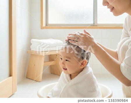 在柔和的燈光下，一位母親溫柔地幫寶寶洗澡。 138390984