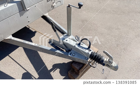 Close up of a professional galvanized trailer hitch mechanism with jockey wheel on asphalt surface 138391085
