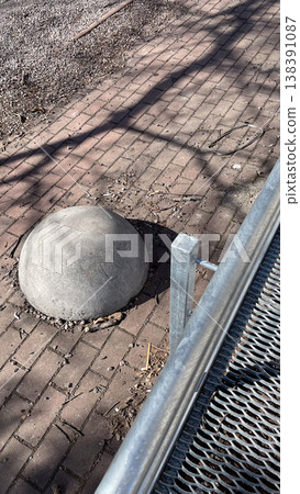 Concrete hemisphere bollard on brick pavement for traffic control and safety in modern urban space Concrete hemisphere bollard on brick pavement for traffic control and safety in modern urban space 138391087