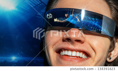 Smiling man wearing futuristic visor with football goalkeeper save reflected in lenses 138391823