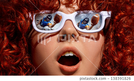Woman with curly hair wearing white sunglasses with american football action reflected. 138391826