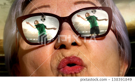 Senior woman in sunglasses watching football match reflected in lenses emotional reaction. 138391849