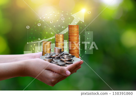 Close up of hands holding stacked gold coins with growth graph and global network on green bokeh background. Close up of hands holding stacked gold coins with growth graph and global network on green bokeh background. 138391860
