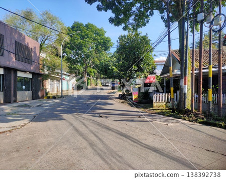 Curved street with trees and mixed homes peaceful daylight scene blends modern and traditional charm. 138392738