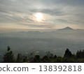 Golden sunrise over misty mountains, creating a peaceful and dreamy natural landscape view. 138392818