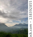 Misty morning mountains under dramatic skies, capturing the calm and mystery of natures dawn veil. 138392855