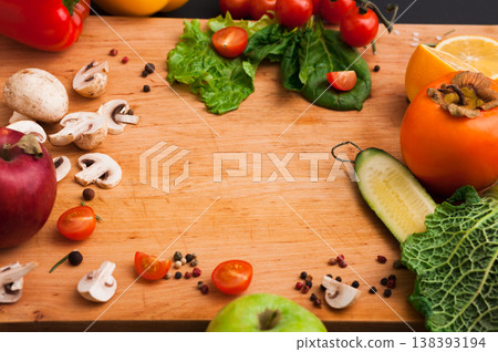 Cooking healthy vegetarian food background. Frame of fresh organic vegetables on black. Natural food and wooden cutting board with copy space. Cooking healthy vegetarian food background. Frame of fresh organic vegetables on black. Natural food and wooden cutting board with copy space. 138393194