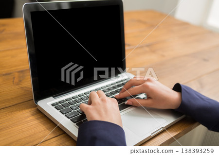 Business woman working in office, typing on laptop, close-up, shallow depth of field 138393259