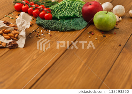 Fresh vegetables, fruits and nuts on rustic wood background with copy space. Healthy natural food on table. Vegetarian cooking ingredients 138393260