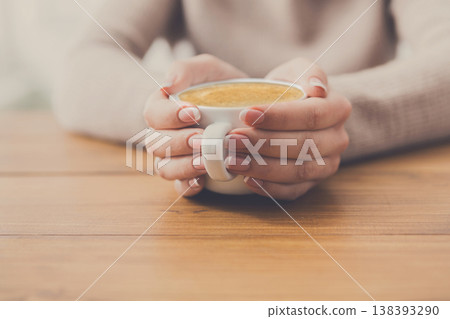 Enjoy cup of coffee. Woman hands closeup with aromatic espresso or americano on wood table Enjoy cup of coffee. Woman hands closeup with aromatic espresso or americano on wood table 138393290