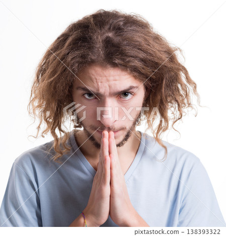 Facial expression and emotions. Hopeful man praying, holding hands clasped near face on white isolated studio background Facial expression and emotions. Hopeful man praying, holding hands clasped near face on white isolated studio background 138393322