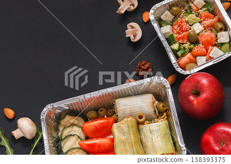 Healthy restaurant food delivery dark background with copy space. Mockup for menu, foil containers with meals on black 138393375