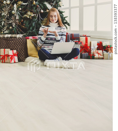 Christmas online shopping. Woman has coffee, buy presents on laptop, prepare to xmas, among gift boxes and packages. Winter sales Christmas online shopping. Woman has coffee, buy presents on laptop, prepare to xmas, among gift boxes and packages. Winter sales 138393377