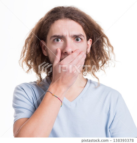 Keep silence. Gossip concept. Surprised man covering mouth with hand on white isolated studio background Keep silence. Gossip concept. Surprised man covering mouth with hand on white isolated studio background 138393378