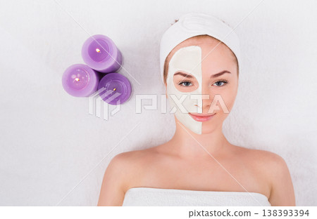 Face mask, spa beauty treatment. Woman applying facial clay mask at spa salon, skincare, top view, overhead 138393394