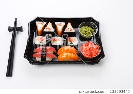 Japanese food restaurant delivery, take away box, sushi maki and roll set. Chopsticks, ginger, wasabi. Meals isolated at white background 138393443