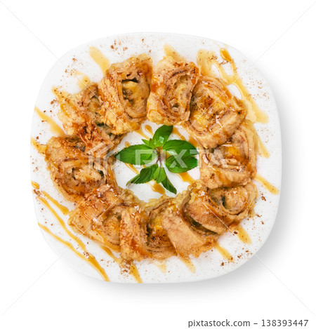 Banana pastry rolls with caramel sauce - restaurant dessert on a square plate isolated at white background 138393447