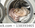 Laundry inside washing machine drum with soft towels and clean fabric 138393465