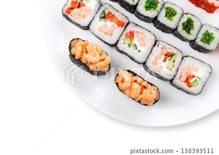 Traditional japanese food delivery. Sushi set served on white plate closeup. Colorful rolls and gunkan assortment at white background with copy space, top view Traditional japanese food delivery. Sushi set served on white plate closeup. Colorful rolls and gunkan assortment at white background with copy space, top view 138393511