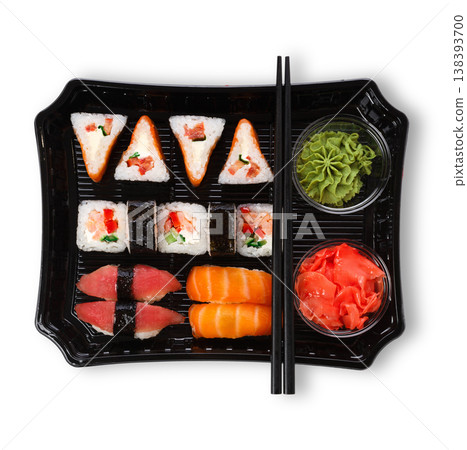 Japanese food restaurant delivery, take away box, sushi maki and roll set. Chopsticks, ginger, soy sauce, wasabi. Meals isolated at white background, top view Japanese food restaurant delivery, take away box, sushi maki and roll set. Chopsticks, ginger, soy sauce, wasabi. Meals isolated at white background, top view 138393700