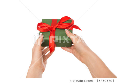 Woman's hands give present box isolated on white. Gift in paper with red ribbon. 138393701