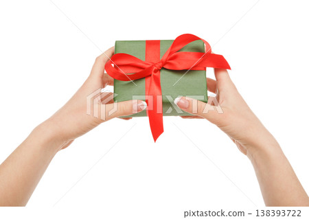 Female hand give present in paper with red ribbon, isolated on white background, close-up, cutout 138393722