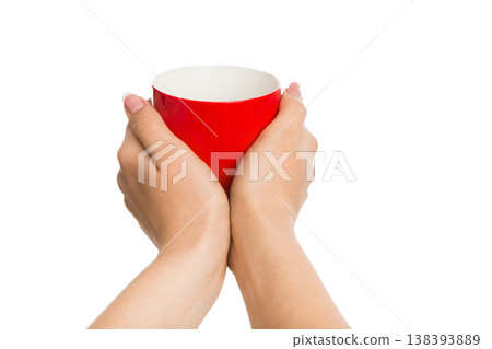 Cup of tea in female hand isolated on white. Red mug with hot drink Cup of tea in female hand isolated on white. Red mug with hot drink 138393889