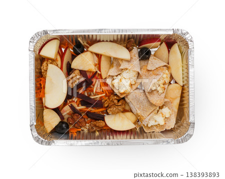 Healthy lunch in foil container. Healthy food take away and delivery. Cuted apples, nuts, beets, olives, carrots and pancakes with cottage cheese in box on white background, closeup, isolated Healthy lunch in foil container. Healthy food take away and delivery. Cuted apples, nuts, beets, olives, carrots and pancakes with cottage cheese in box on white background, closeup, isolated 138393893