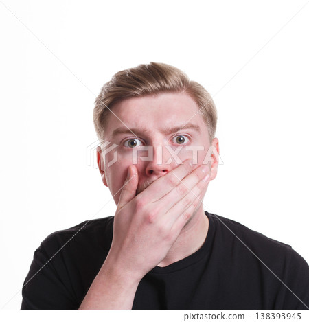 Keep silence. Gossip concept. Surprised man covering mouth with hand on white isolated studio background Keep silence. Gossip concept. Surprised man covering mouth with hand on white isolated studio background 138393945