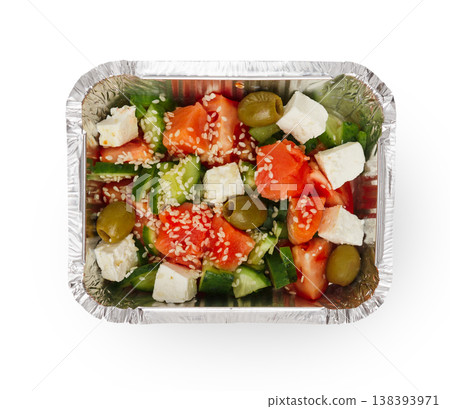 Healthy lunch in foil container. Healthy food take away and delivery. Salad, cuted tomatoes, olives, cucumbers, feta with sesame in box on white background, closeup, isolated Healthy lunch in foil container. Healthy food take away and delivery. Salad, cuted tomatoes, olives, cucumbers, feta with sesame in box on white background, closeup, isolated 138393971