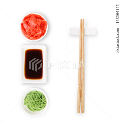 Set of sushi tablewear. Top view on saucer with soy sauce, small white bowls for ginger and wasabi and chopsticks at white background. Flat lay, copy space 138394125