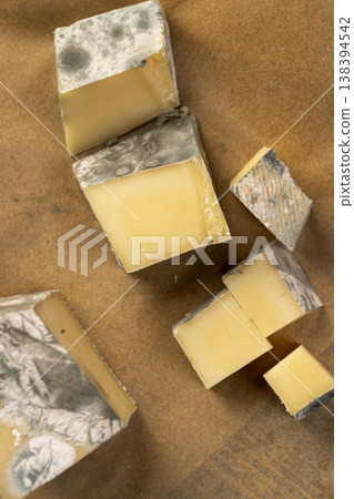 an old orange cheese with a lot of colorful mold, an inedible and dangerous cheese that was spoiled during the improper storage, the cheese is covered with mold dangerous to health an old orange cheese with a lot of colorful mold, an inedible and dangerous cheese that was spoiled during the improper storage, the cheese is covered with mold dangerous to health 138394542