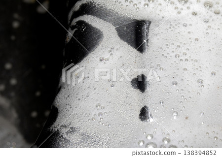 Close up of washing up liquid bubbles flowing down the kitchen sink 138394852