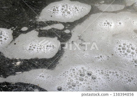 Close up of washing up liquid bubbles flowing down the kitchen sink Close up of washing up liquid bubbles flowing down the kitchen sink 138394856
