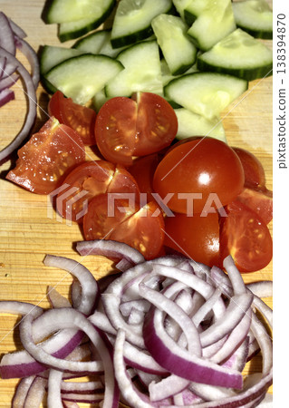 Close up of finely chopped sliced red onion salad vegetables on wooden chopping board Close up of finely chopped sliced red onion salad vegetables on wooden chopping board 138394870