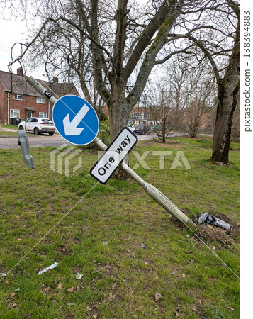 One way sign that a car has driven into a broken knocked over damaged traffic pole 138394883