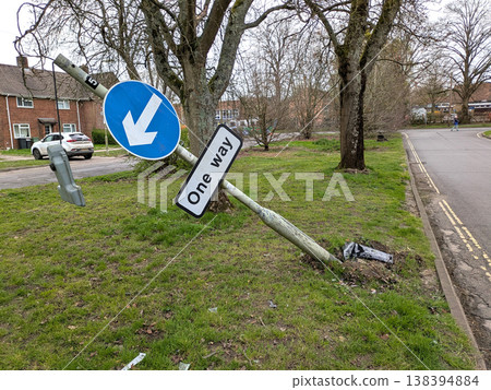 One way sign that a car has driven into a broken knocked over damaged traffic pole One way sign that a car has driven into a broken knocked over damaged traffic pole 138394884