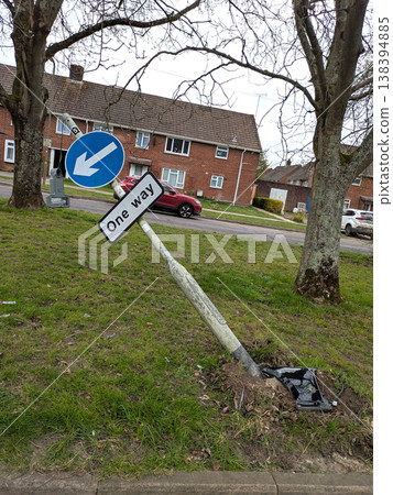 One way sign that a car has driven into a broken knocked over damaged traffic pole 138394885