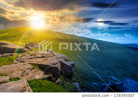 rocks and rolling hills in mountain landscape on summer solstice. day meet night. sun and moon over scenery with green grass on alpine meadow. astrology recreation tourism and wanderlust 138395087