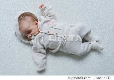 Infant lying on clean white background in minimal style. Simple and aesthetic baby portrait. Perfect for parenting, healthcare, and lifestyle concepts 138395812
