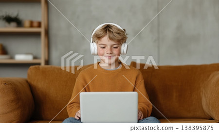 Cheerful boy headphones laptop studying online education learning home technology remote class 138395875